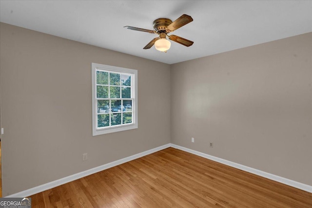 empty room featuring light wood finished floors, ceiling fan, and baseboards