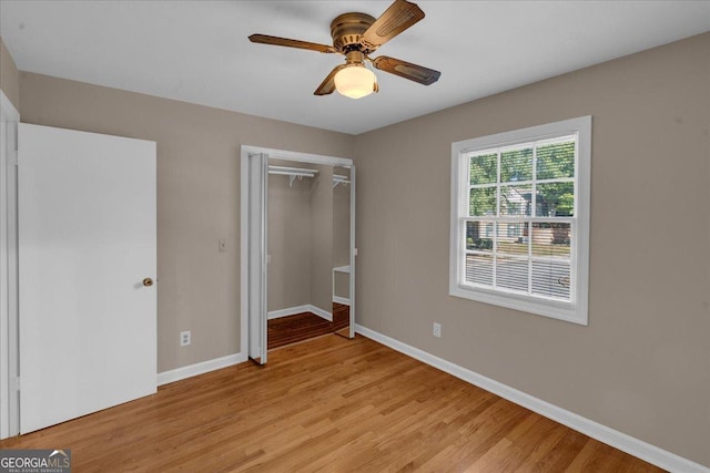 unfurnished bedroom featuring a closet, a ceiling fan, baseboards, and light wood finished floors