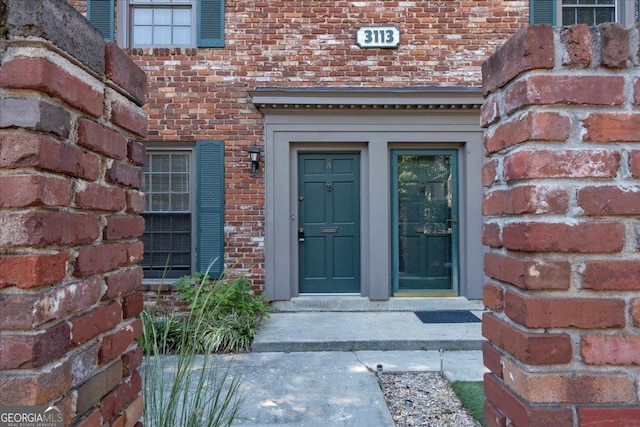 doorway to property with brick siding