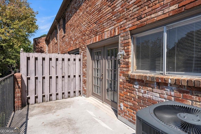 view of patio / terrace featuring central AC unit, french doors, and fence