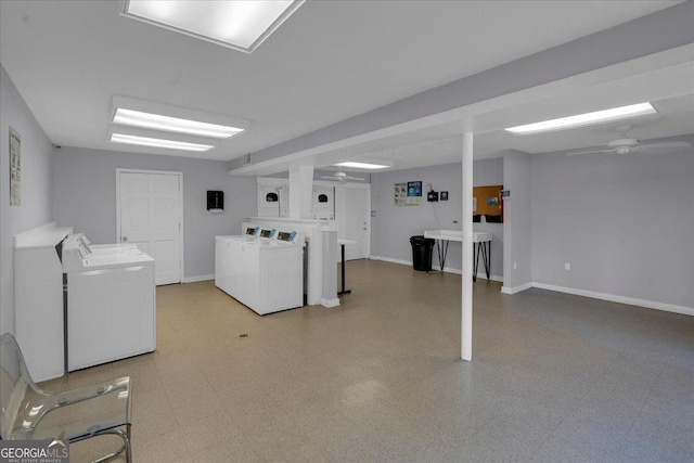 finished basement featuring baseboards, light floors, and washing machine and dryer