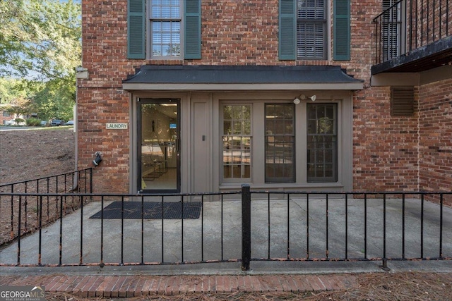 property entrance with brick siding and fence