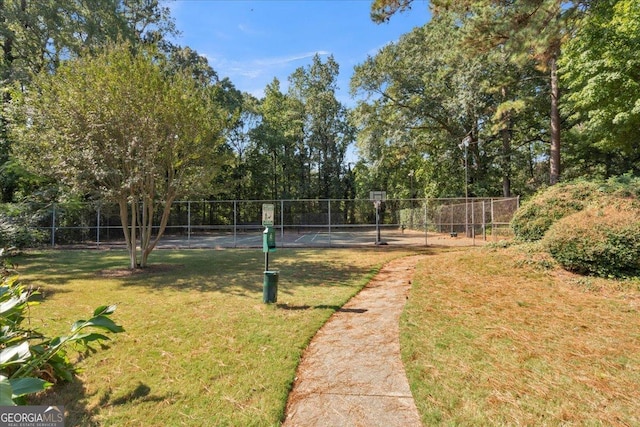 view of yard featuring community basketball court and fence