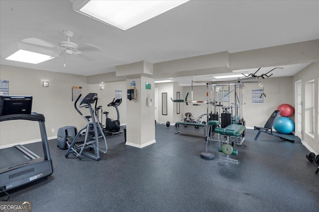 gym with baseboards and a ceiling fan