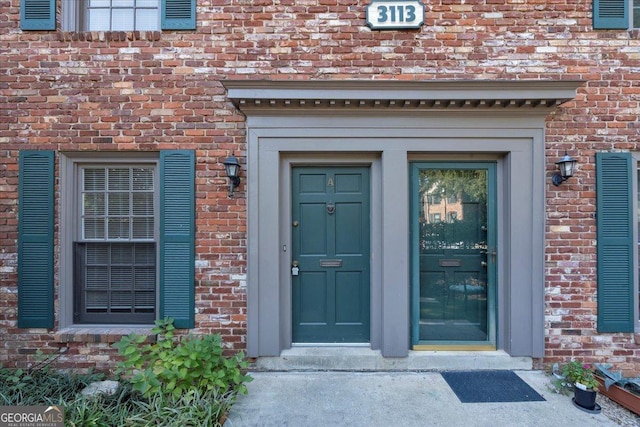 view of exterior entry with brick siding