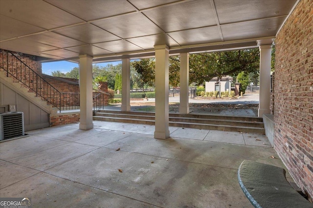 view of patio featuring stairway, central air condition unit, and an outbuilding