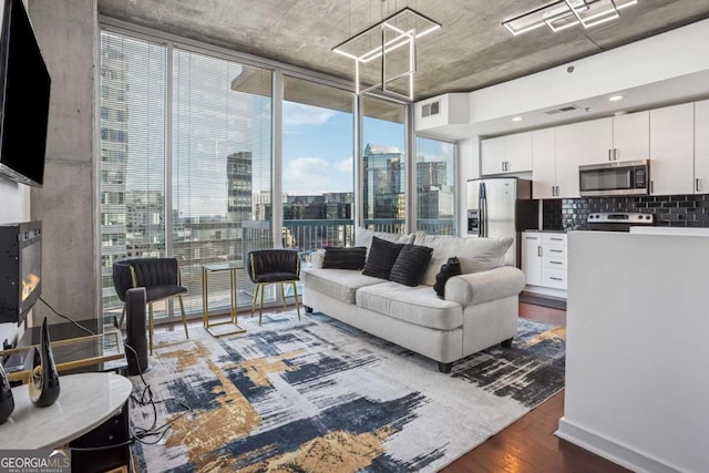 living area featuring a wall of windows, visible vents, a view of city, and dark wood-type flooring