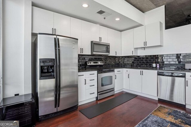3324 Peachtree Rd NE Unit 1115, Atlanta, GA 30326 - kitchen with dark countertops, visible vents, tasteful backsplash, appliances with stainless steel finishes, and dark wood-style flooring
