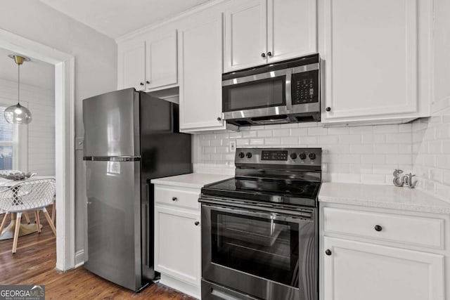 kitchen with white cabinetry, light countertops, wood finished floors, and appliances with stainless steel finishes