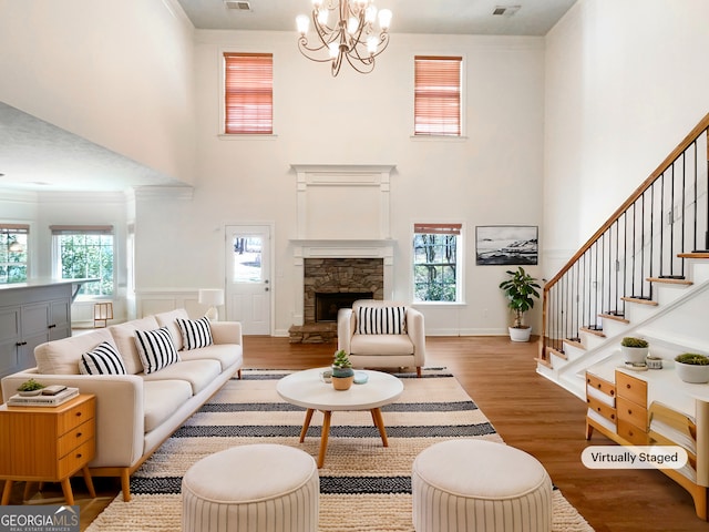 living room with a chandelier, a healthy amount of sunlight, wood finished floors, and visible vents