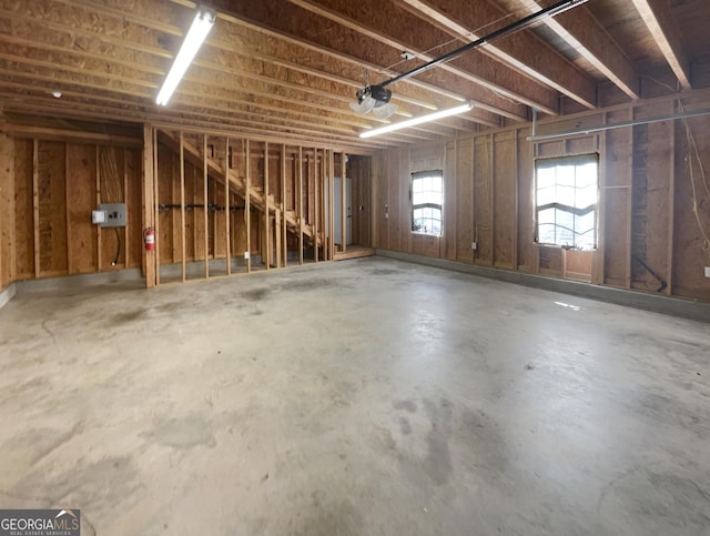 misc room with a garage and concrete floors