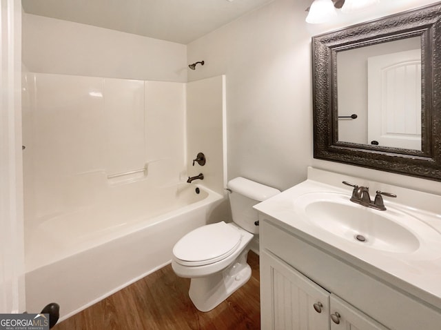 bathroom with shower / bathing tub combination, toilet, wood finished floors, and vanity