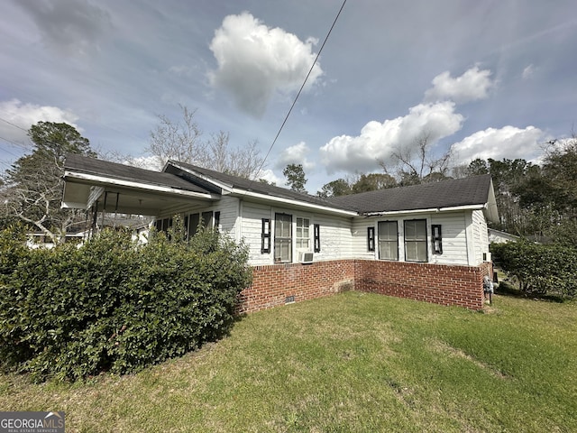 view of front of home featuring a front lawn, cooling unit, and brick siding