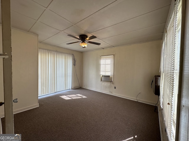 spare room featuring cooling unit, baseboards, ceiling fan, and dark carpet