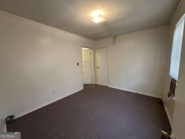 unfurnished room with cooling unit and dark colored carpet