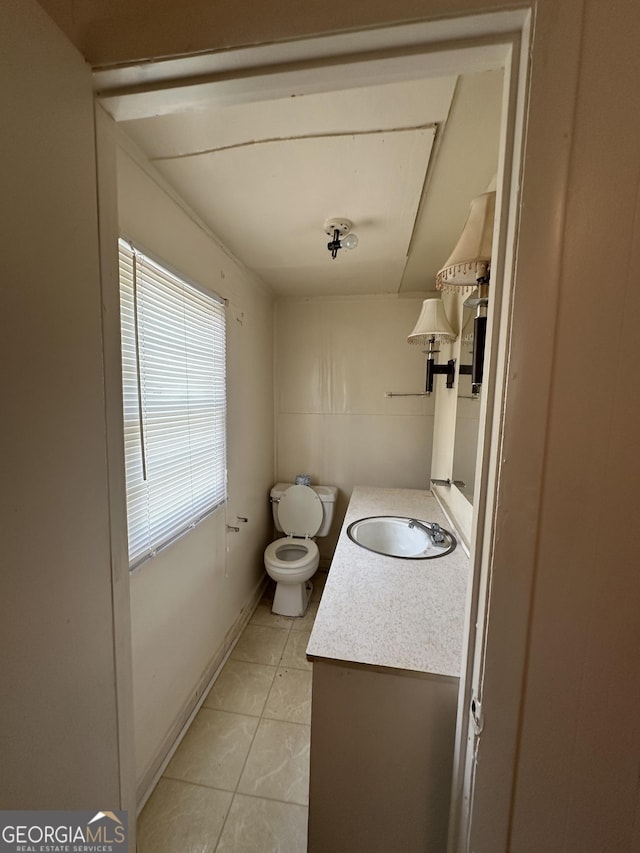 bathroom featuring baseboards, toilet, vanity, and tile patterned flooring