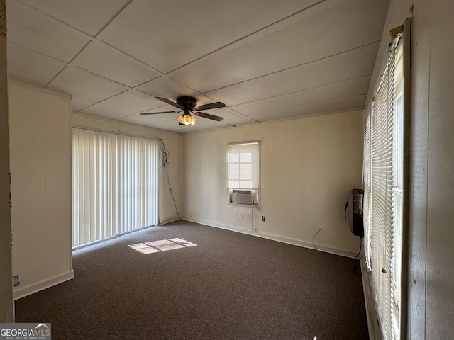 empty room featuring cooling unit, baseboards, dark colored carpet, and ceiling fan