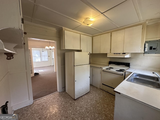 kitchen with white appliances, a sink, under cabinet range hood, cream cabinets, and a chandelier