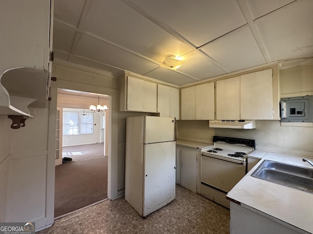 kitchen featuring light countertops, cream cabinets, an inviting chandelier, white appliances, and a sink