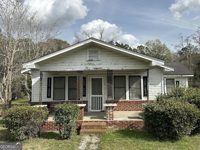 bungalow-style house with brick siding and a porch