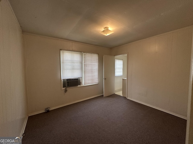 unfurnished room featuring dark carpet, cooling unit, and baseboards