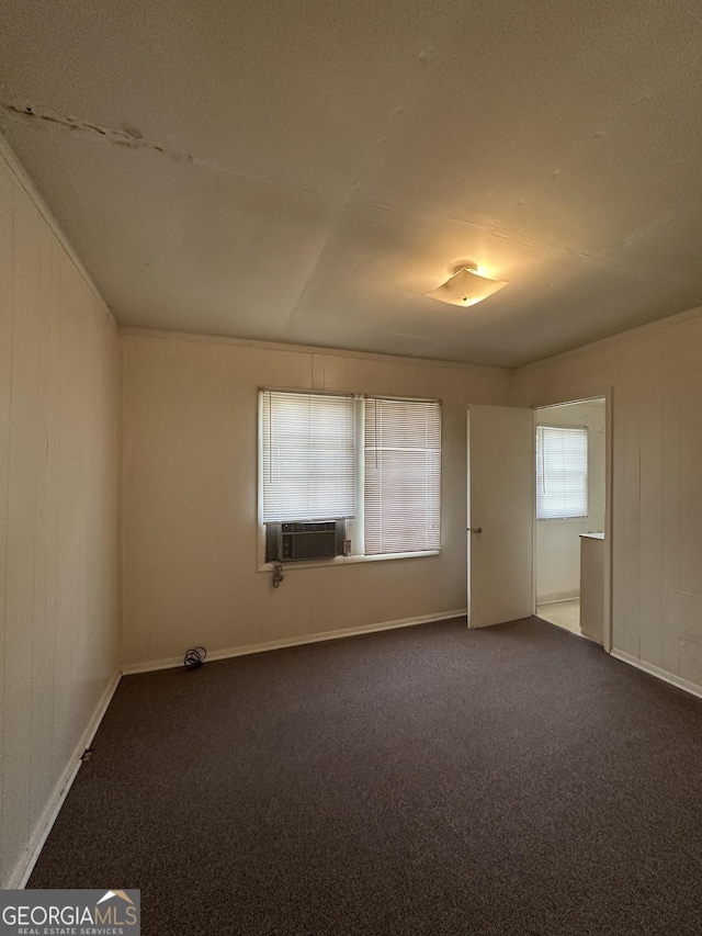 unfurnished room featuring cooling unit and dark colored carpet