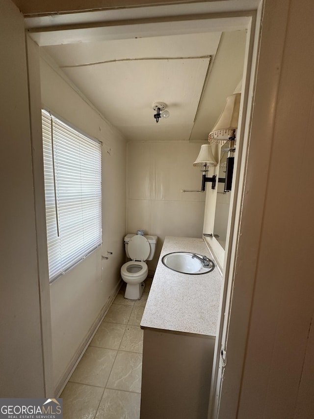 half bathroom featuring vanity, tile patterned floors, and toilet