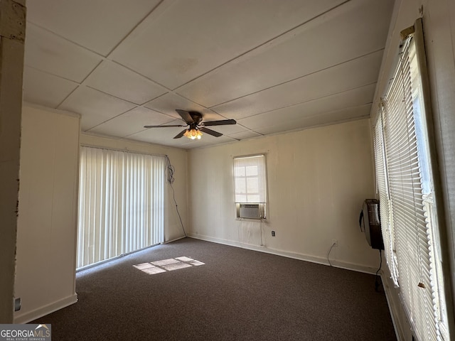 unfurnished room featuring baseboards, ceiling fan, and dark carpet