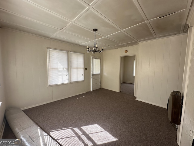 interior space with heating unit, a notable chandelier, and dark carpet