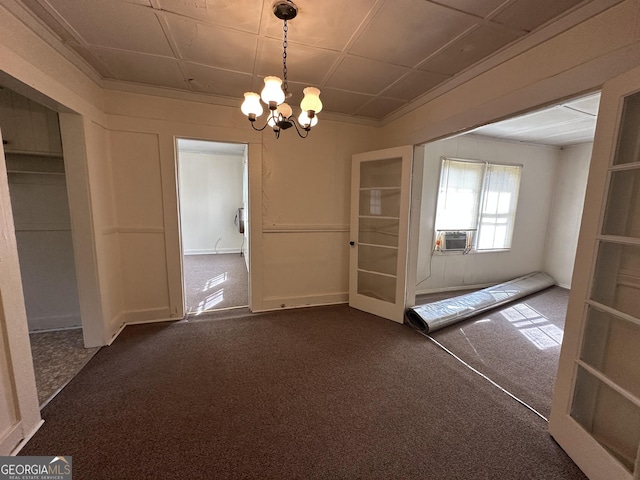 unfurnished dining area with cooling unit, a chandelier, dark carpet, and ornamental molding