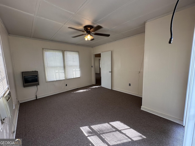 unfurnished room with heating unit, baseboards, a ceiling fan, and dark colored carpet