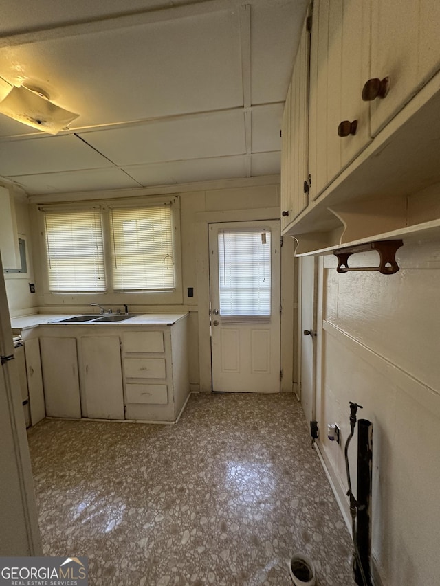 kitchen featuring light countertops, light floors, and a sink