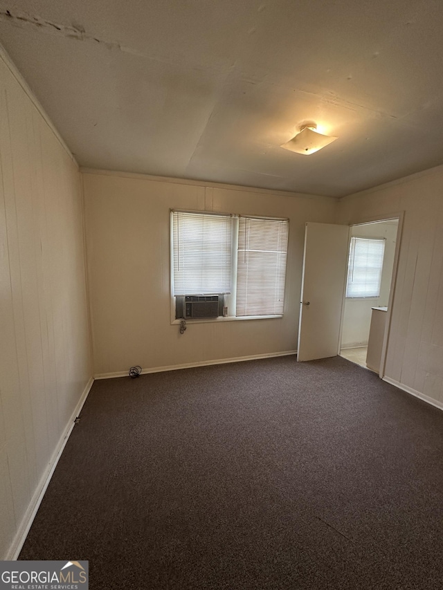 empty room featuring dark carpet and cooling unit