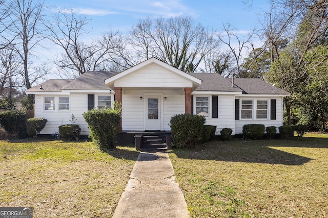 view of front of property featuring roof with shingles and a front lawn