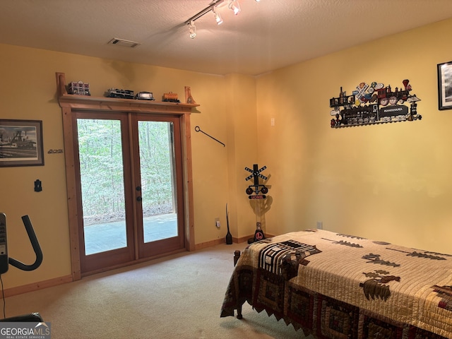 carpeted bedroom featuring french doors, baseboards, visible vents, access to outside, and rail lighting