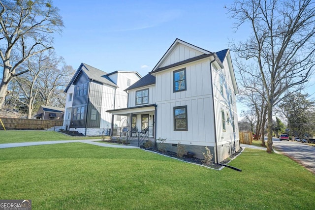 modern inspired farmhouse with board and batten siding, a front yard, and fence