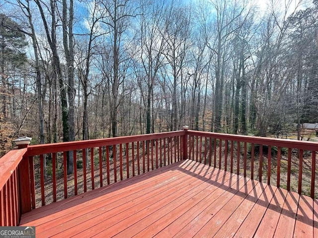 wooden terrace featuring a wooded view