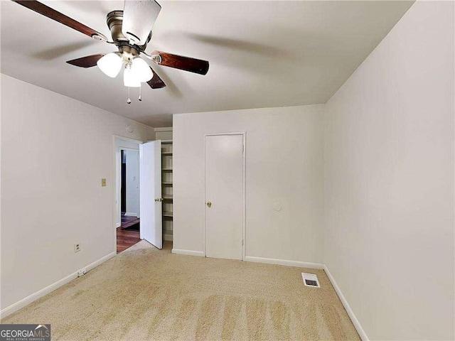 unfurnished bedroom featuring visible vents, a ceiling fan, baseboards, and carpet floors