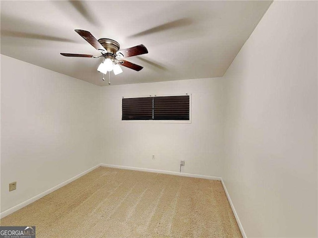 empty room featuring baseboards, light colored carpet, and a ceiling fan