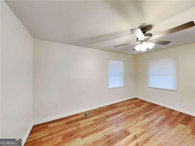 empty room featuring visible vents, baseboards, ceiling fan, and light wood finished floors