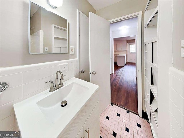 bathroom with wainscoting, tile walls, and vanity