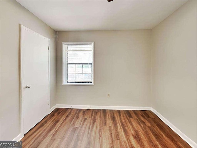 empty room featuring baseboards and wood finished floors