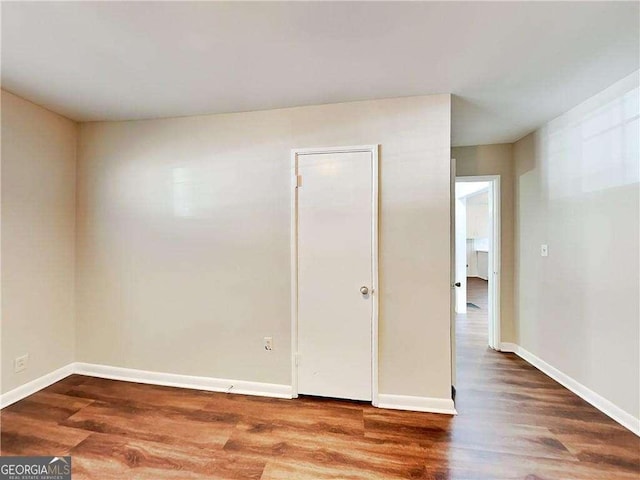 unfurnished room with baseboards and wood finished floors