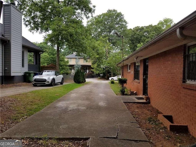 view of home's exterior featuring brick siding and concrete driveway