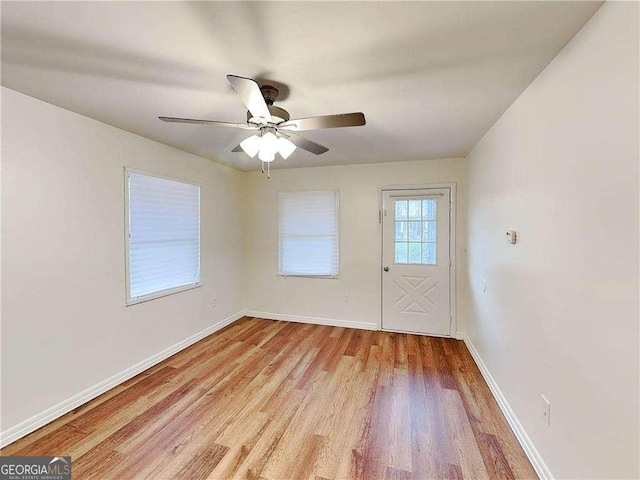 interior space with light wood-style flooring, baseboards, and ceiling fan