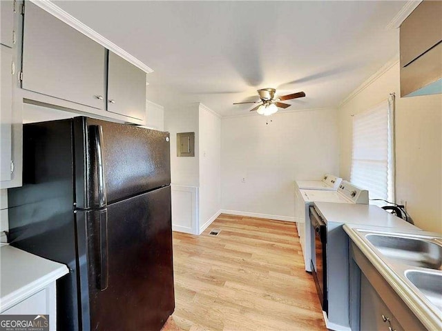 kitchen with light wood finished floors, washing machine and dryer, light countertops, freestanding refrigerator, and a ceiling fan