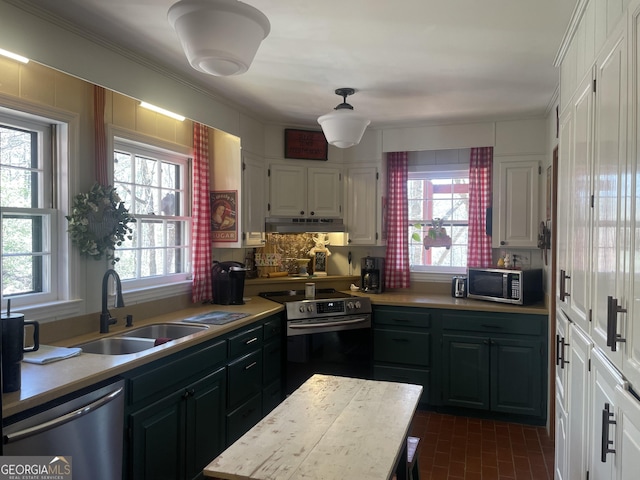 kitchen featuring under cabinet range hood, light countertops, stainless steel appliances, white cabinetry, and a sink