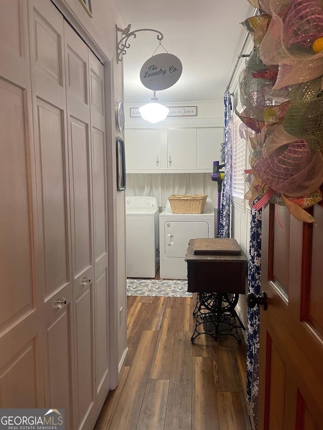 washroom with washer and dryer, cabinet space, and wood-type flooring