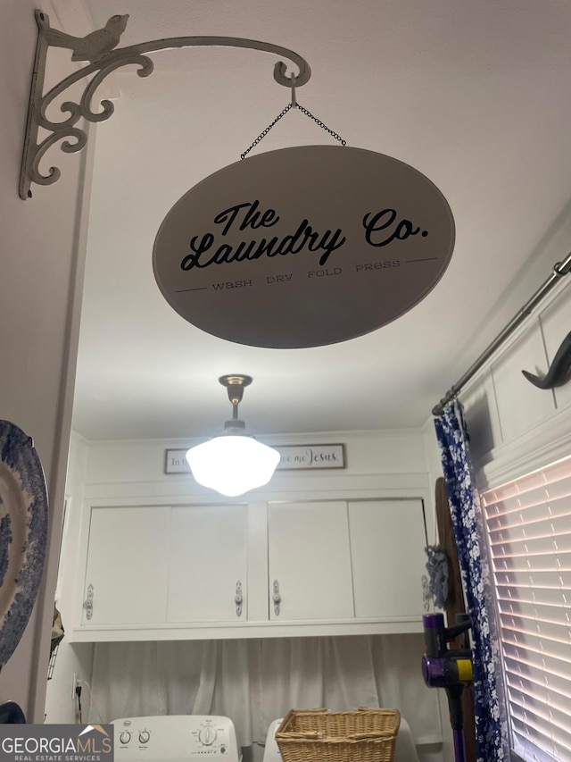 interior details featuring washer / dryer and white cabinets