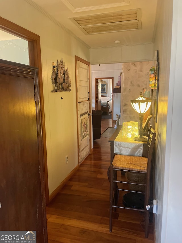 hallway with dark wood-style floors, baseboards, and ornamental molding